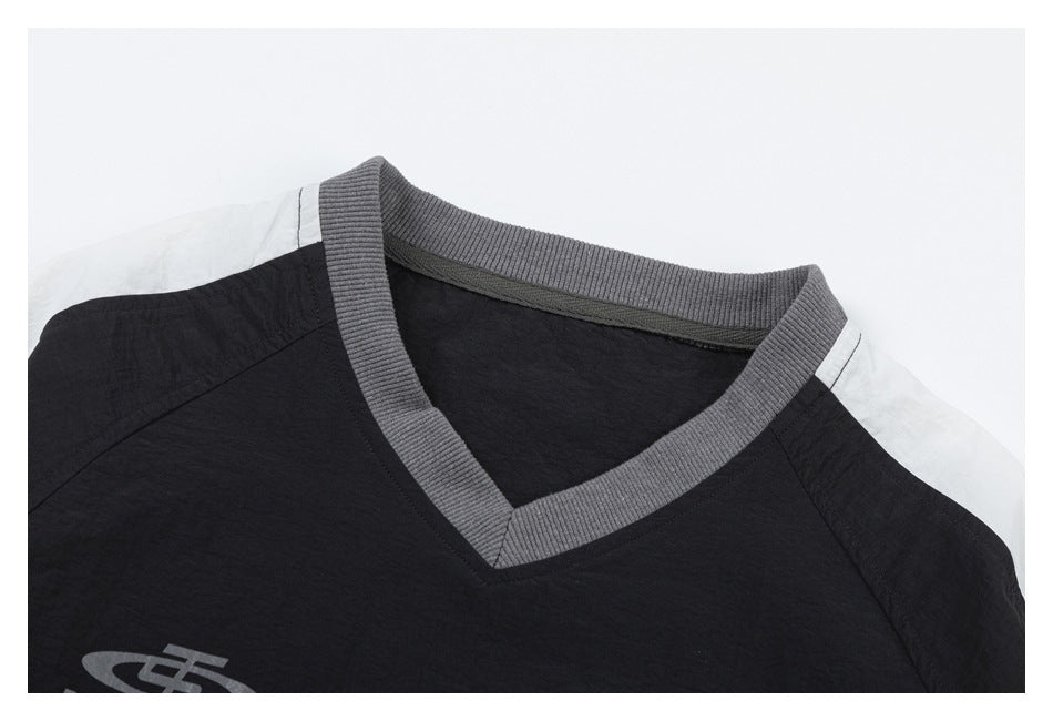 Close-up of the black top’s gray ribbed V-neck, shoulder seams, and off-white shoulder panels.