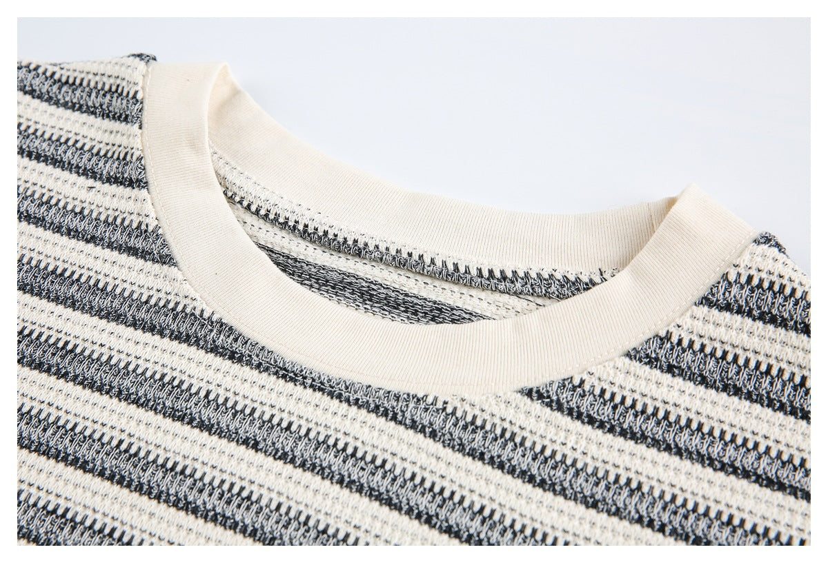 Close-up of the ivory ribbed crew neckline and black-and-ivory striped knit fabric.