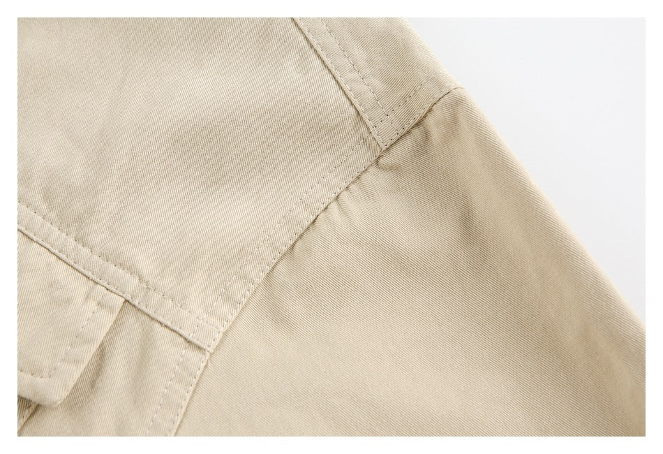 Close-up of beige shirt fabric showing stitched shoulder and panel seams.