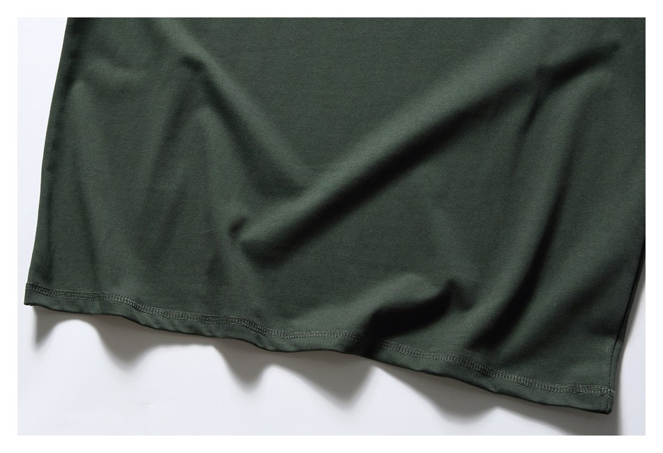 Close-up of the dark green T-shirt's stitched lower hem.