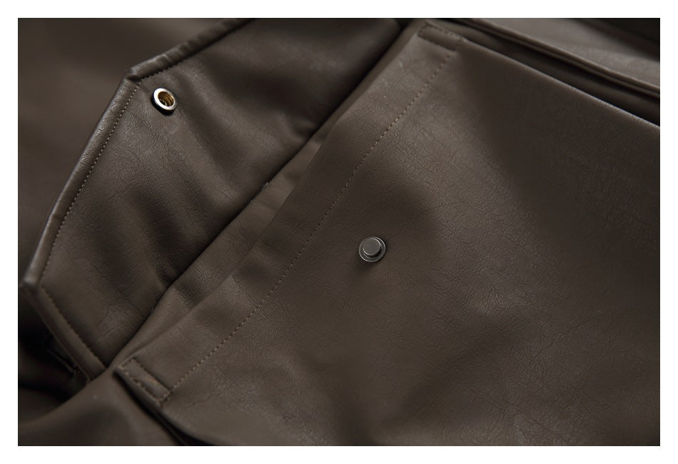 Close-up of snap fasteners and stitching on a dark brown jacket.