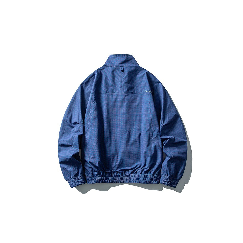 Back view of a subtly patterned blue jacket with a stand collar and elasticated cuffs and hem.