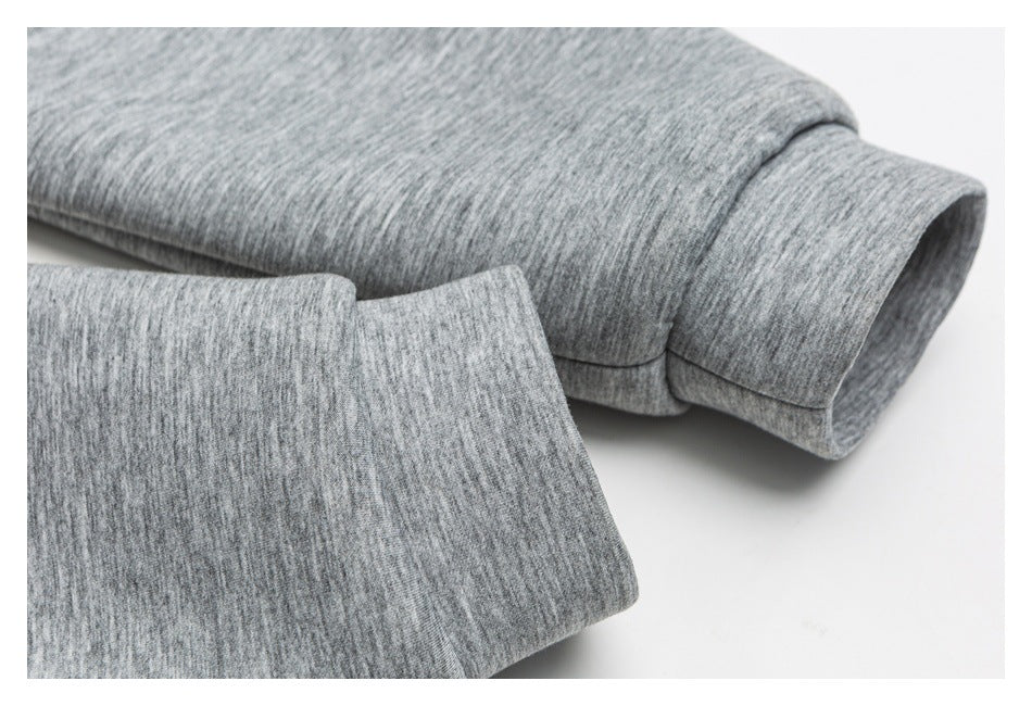 Close-up of a ribbed cuff and folded sleeve in heather gray knit fabric.