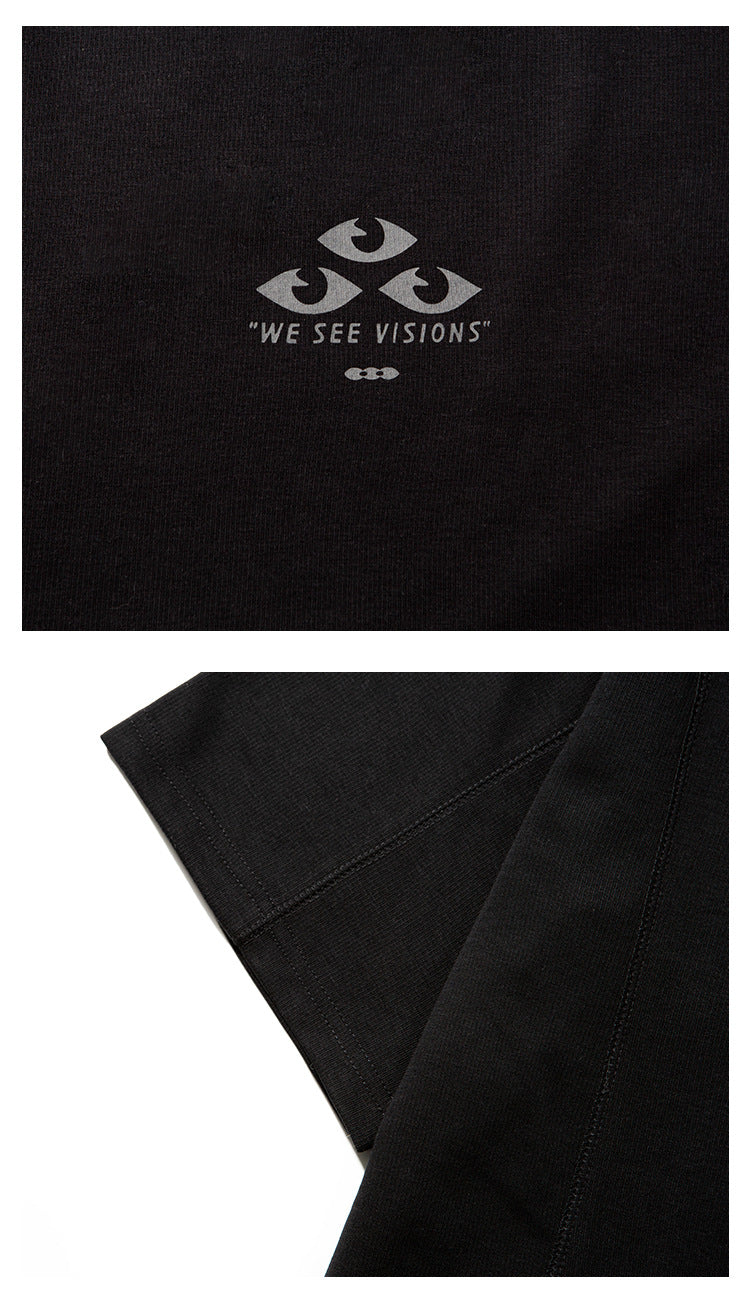 Close-up of the gray eye graphic and lettering on a black T-shirt, with a separate view of the sleeve seam.