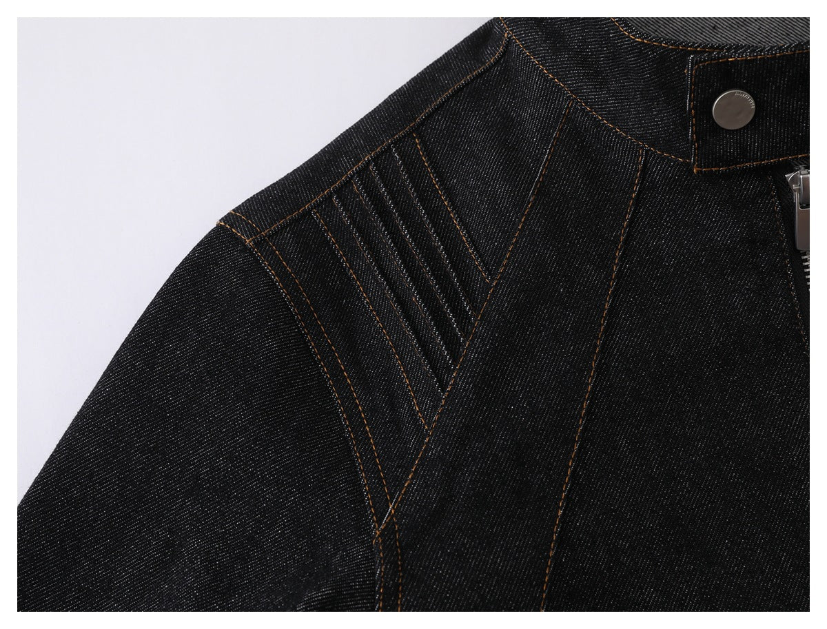 Close-up of a black denim jacket shoulder with decorative panel seams and contrasting topstitching.
