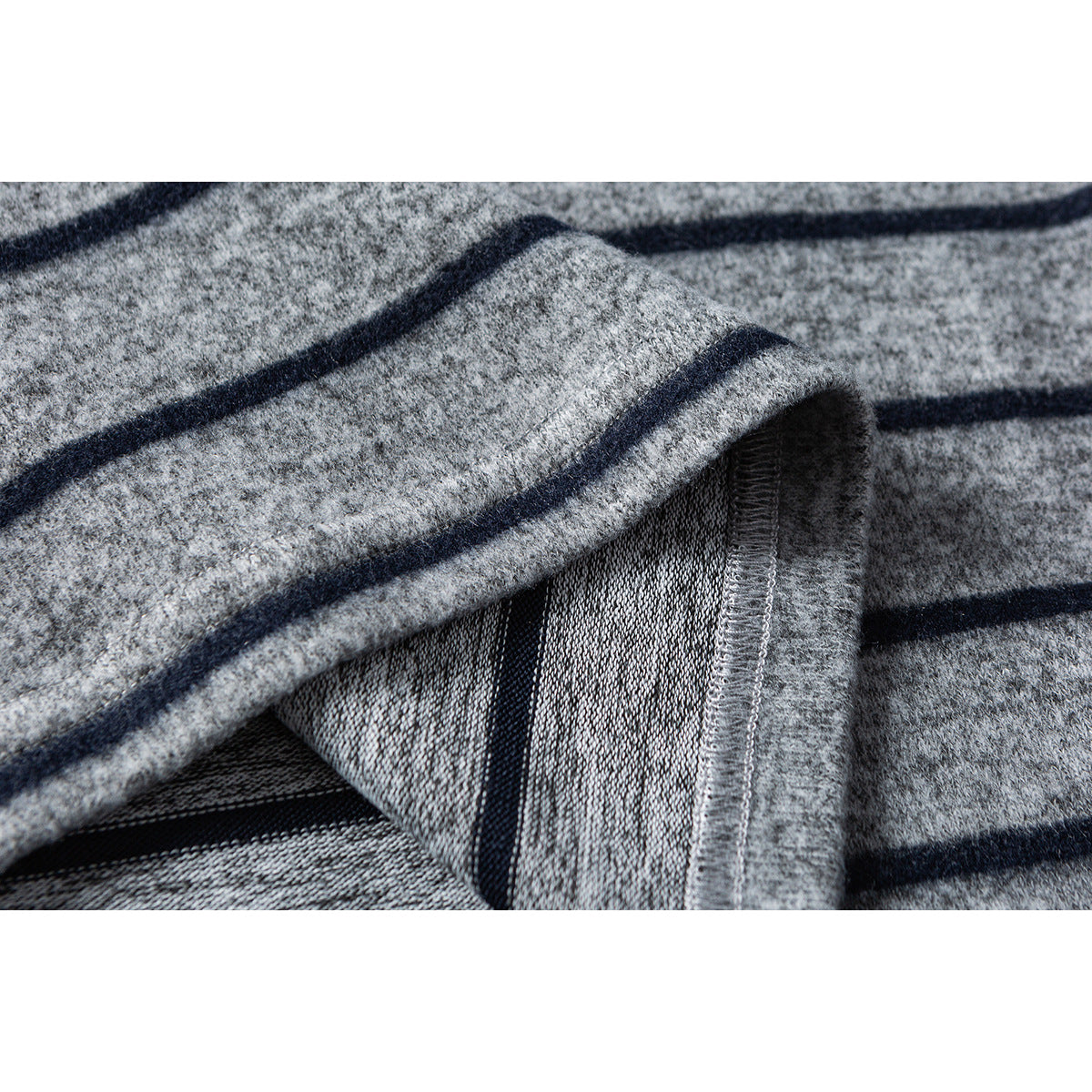 Close-up of a gray striped shirt's folded edge, showing the inner surface and overlocked seam.
