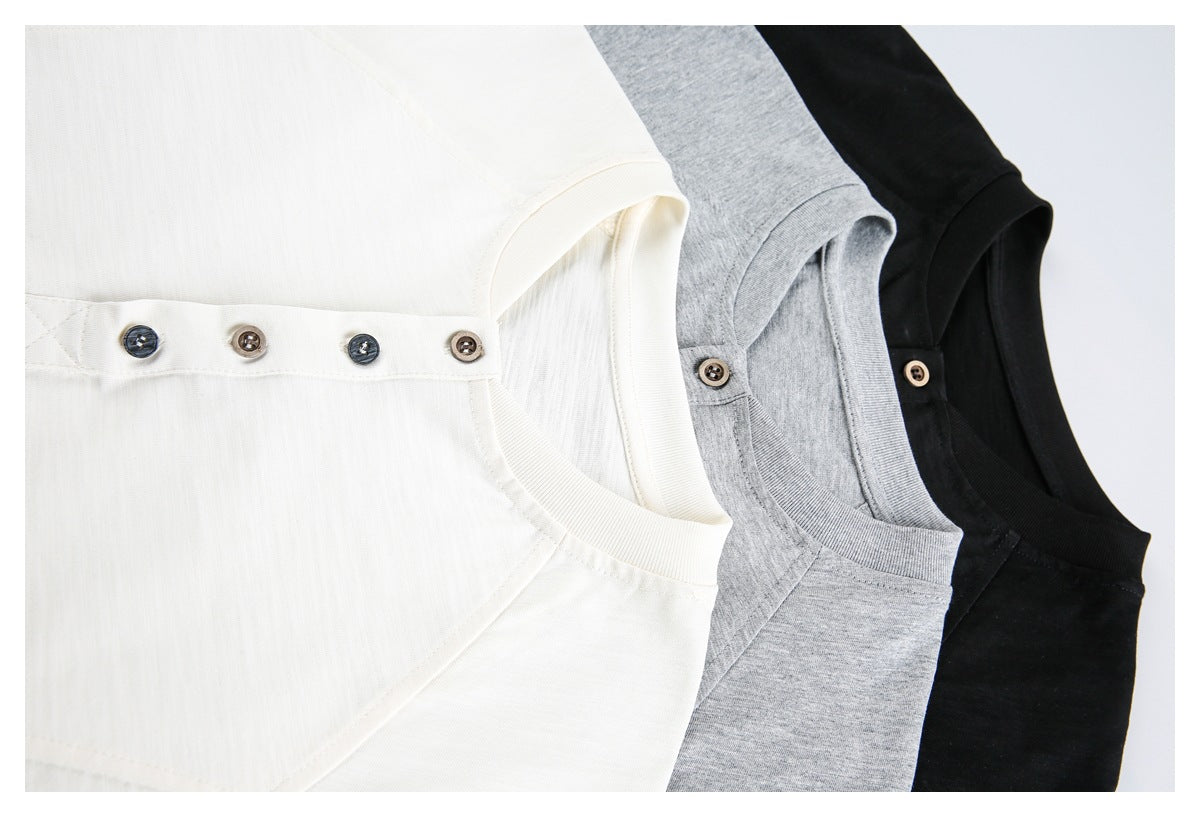 Close-up of ivory, heather gray, and black shirts arranged to show their necklines and buttons.