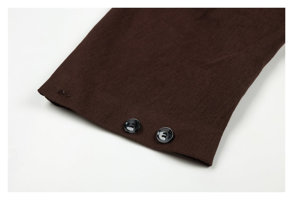 Close-up of a dark brown sleeve cuff with two glossy black buttons.