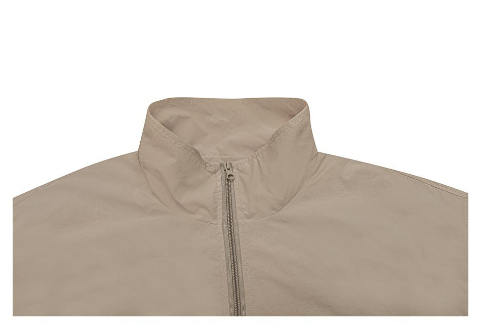 Cropped front view of a beige jacket with a tall collar and center zipper.