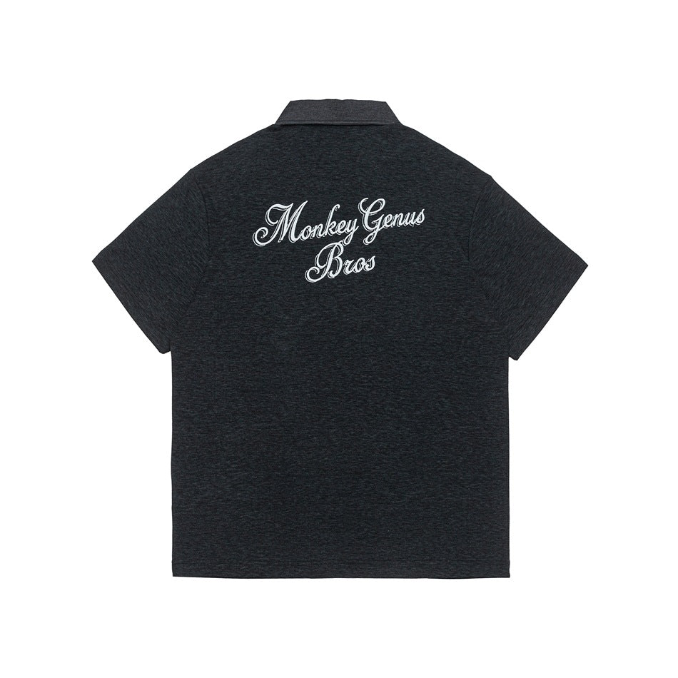 Back view of a charcoal heather short-sleeve collared shirt with large white script embroidery across the upper back.