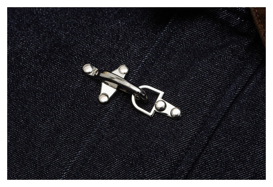 Close-up of a shiny silver toggle clasp on dark indigo denim.