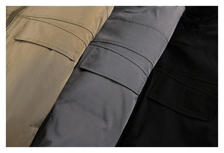 Close-up of cargo trousers in tan, gray, and black, showing stitched flap pockets.