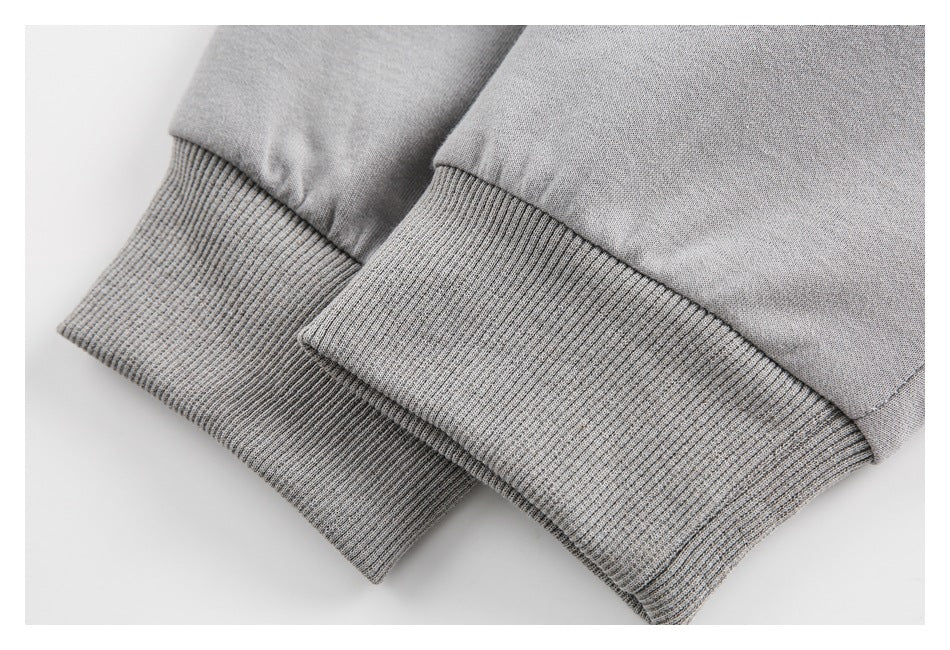 Close-up of two gray garment cuffs with wide ribbed knit bands.