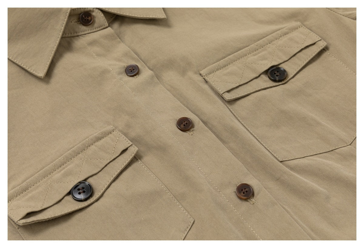 Close-up of the khaki shirt's button placket and two flap chest pockets with dark buttons.