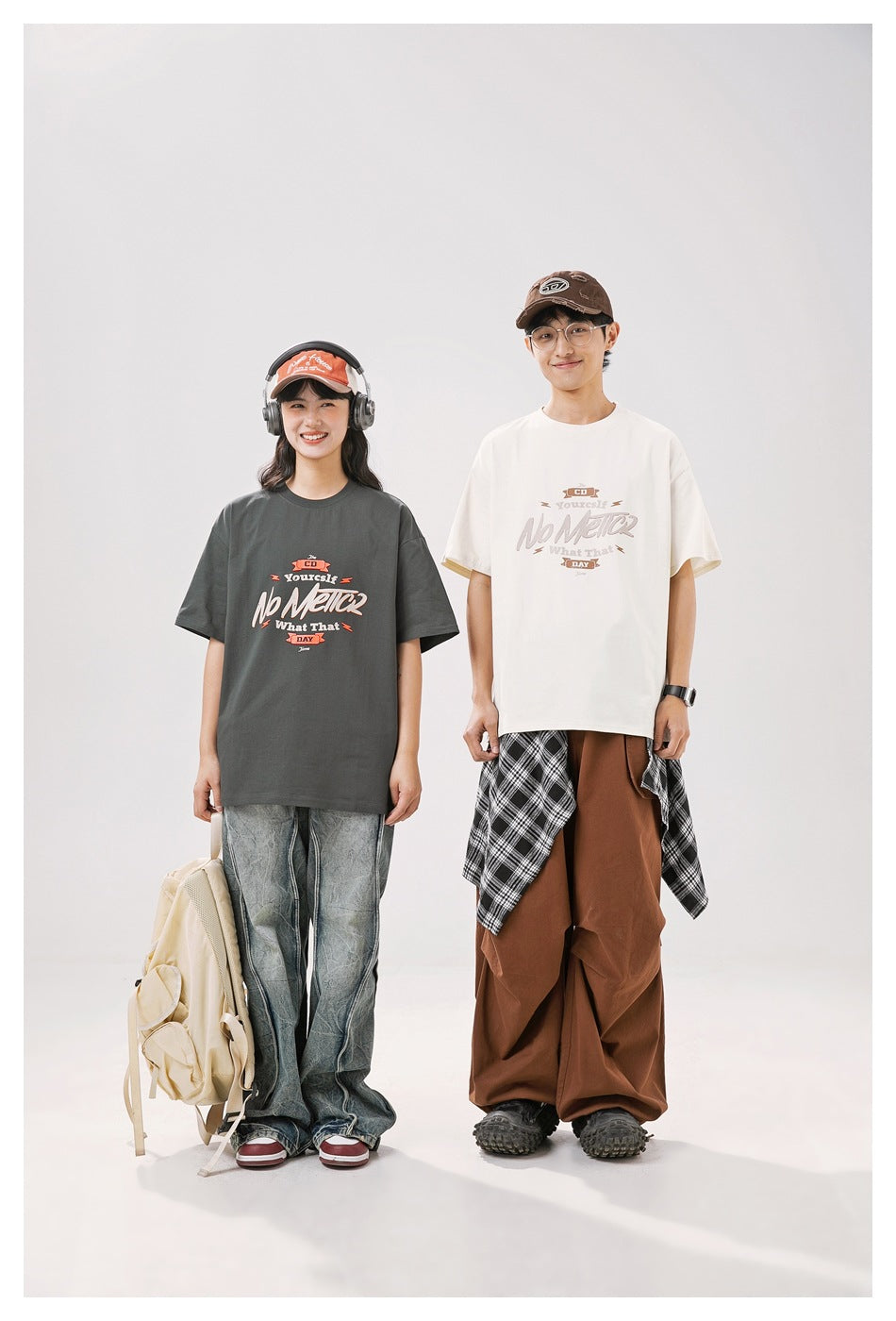 Two models show charcoal and off-white oversized graphic T-shirts from the front.