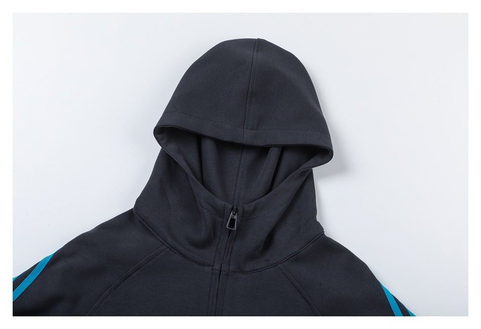 Close-up of the charcoal hoodie’s hood, raised collar, front zipper, and cyan sleeve stripes.