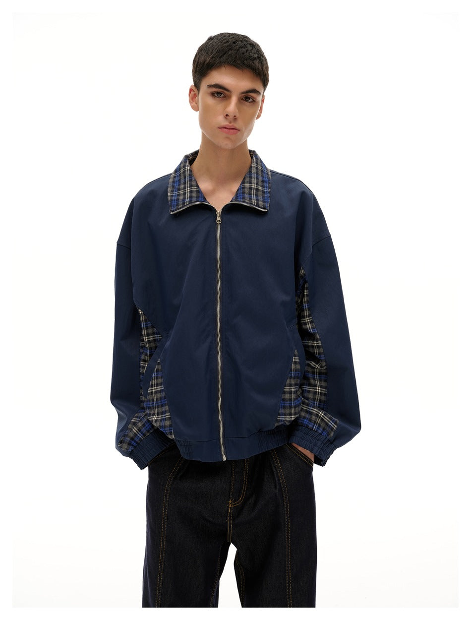Model wearing a navy zip-front jacket with a blue, black and white plaid collar and side panels.