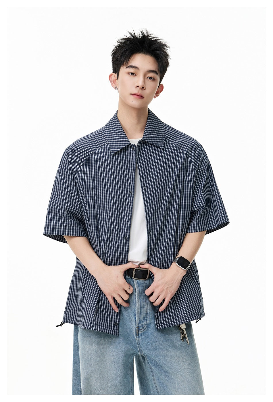 Model wearing an open dark navy plaid short-sleeve shirt over a white T-shirt.