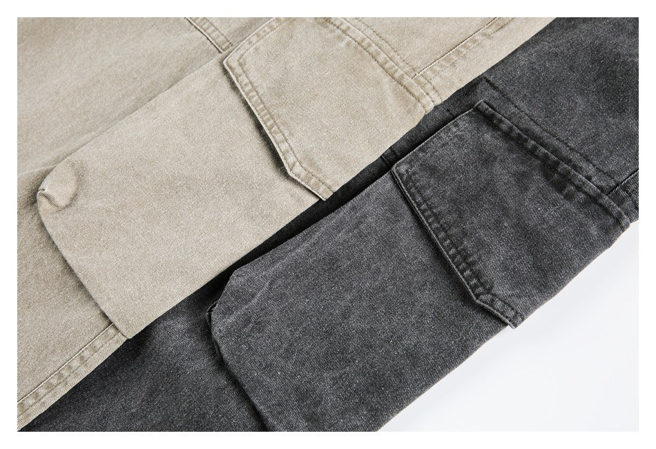 Close-up of beige and charcoal gray pants overlapping, showing fabric texture and seams.