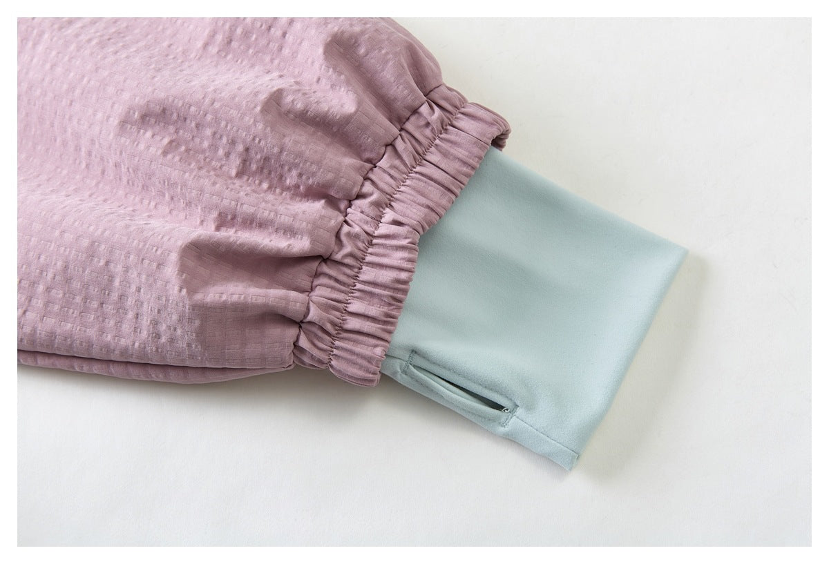 Close-up of a dusty pink sleeve with a gathered cuff over a pale blue inner cuff.