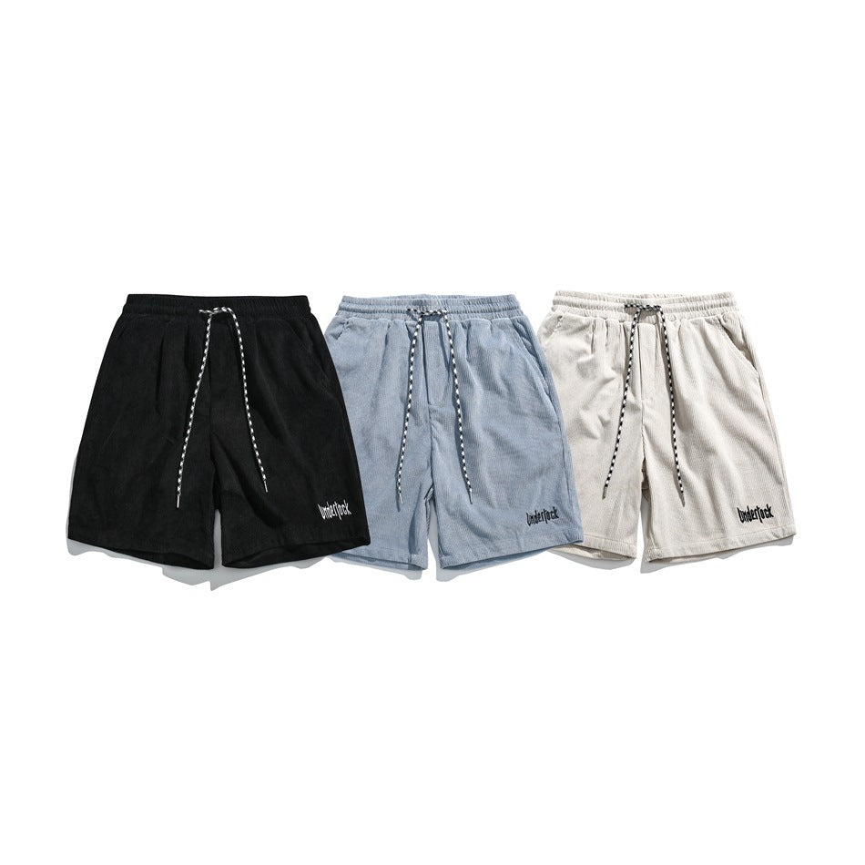 Front view of black, light blue, and cream corduroy shorts with elastic waists and patterned drawstrings.