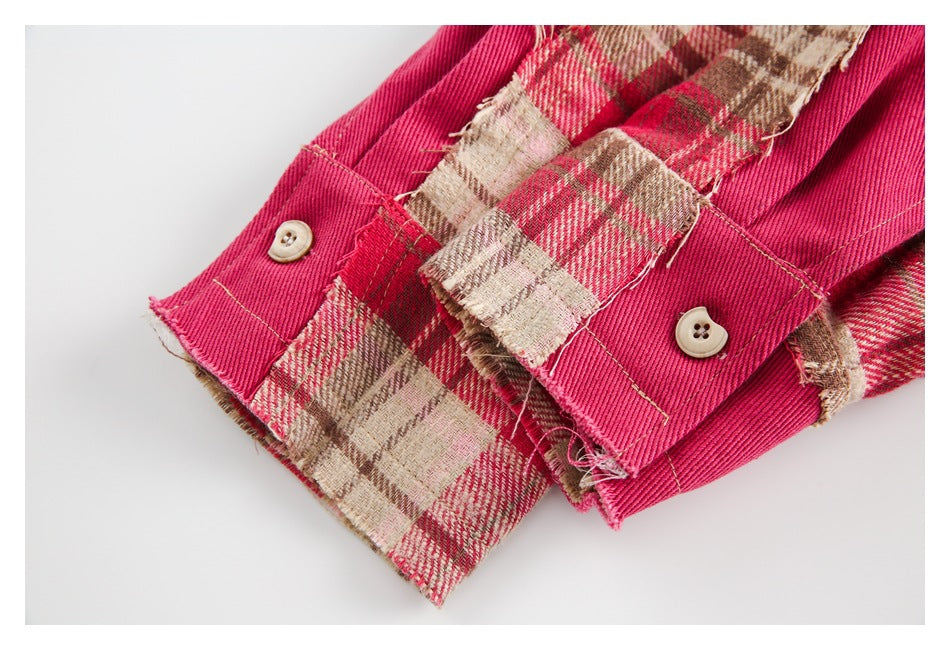 Close-up of plaid garment edges, bright pink facing, and cream buttons.