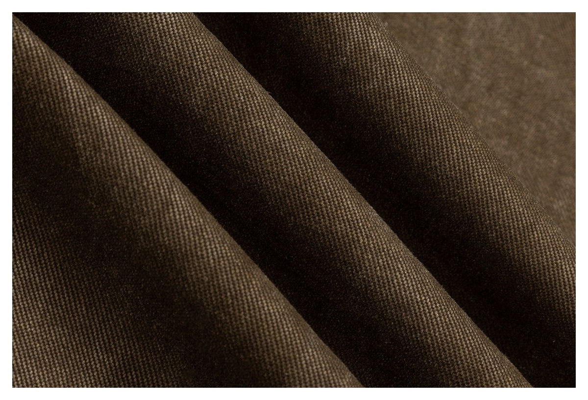 Extreme close-up showing the dark brown garment fabric’s visible weave and folds.