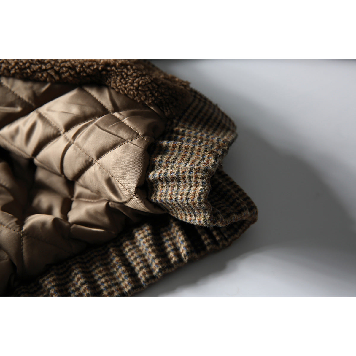 Close-up of a brown quilted jacket lining beside its brown-and-tan checked outer fabric.