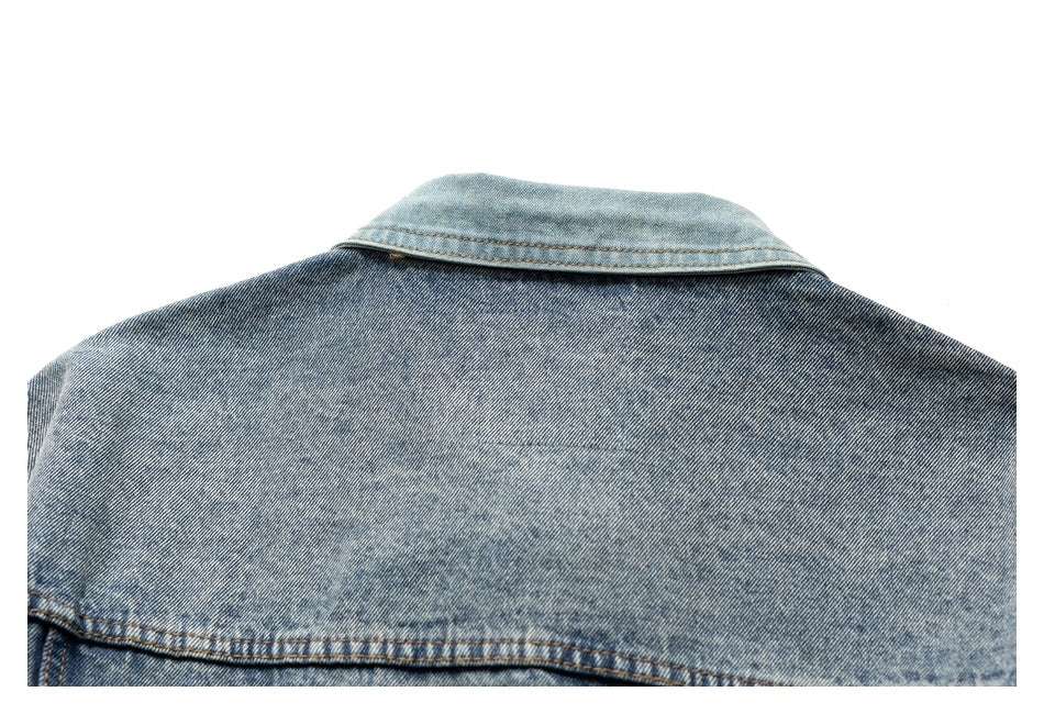 Upper back of a blue denim jacket, showing its contrasting light blue collar and back yoke.