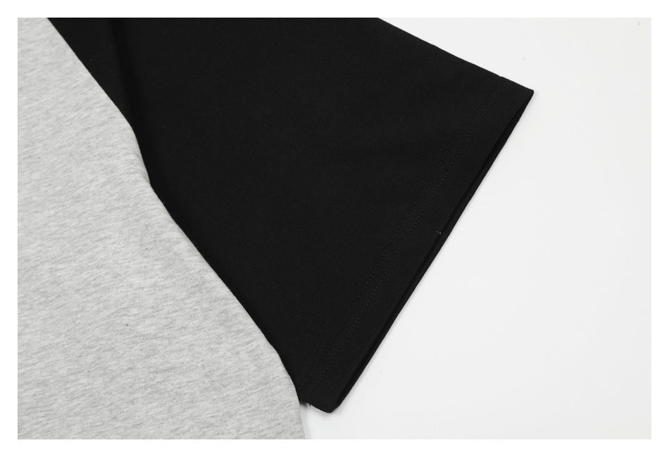 Close-up of black and heather-gray garment fabric with a stitched edge.