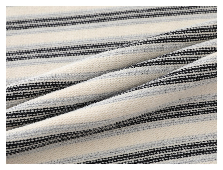 Close-up of cream fabric with black and gray horizontal stripes and a textured weave.