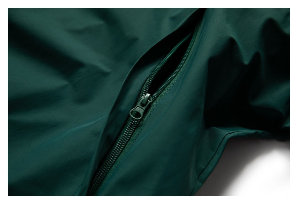 Close-up of a dark teal garment with a partially open zipper and matching fabric.