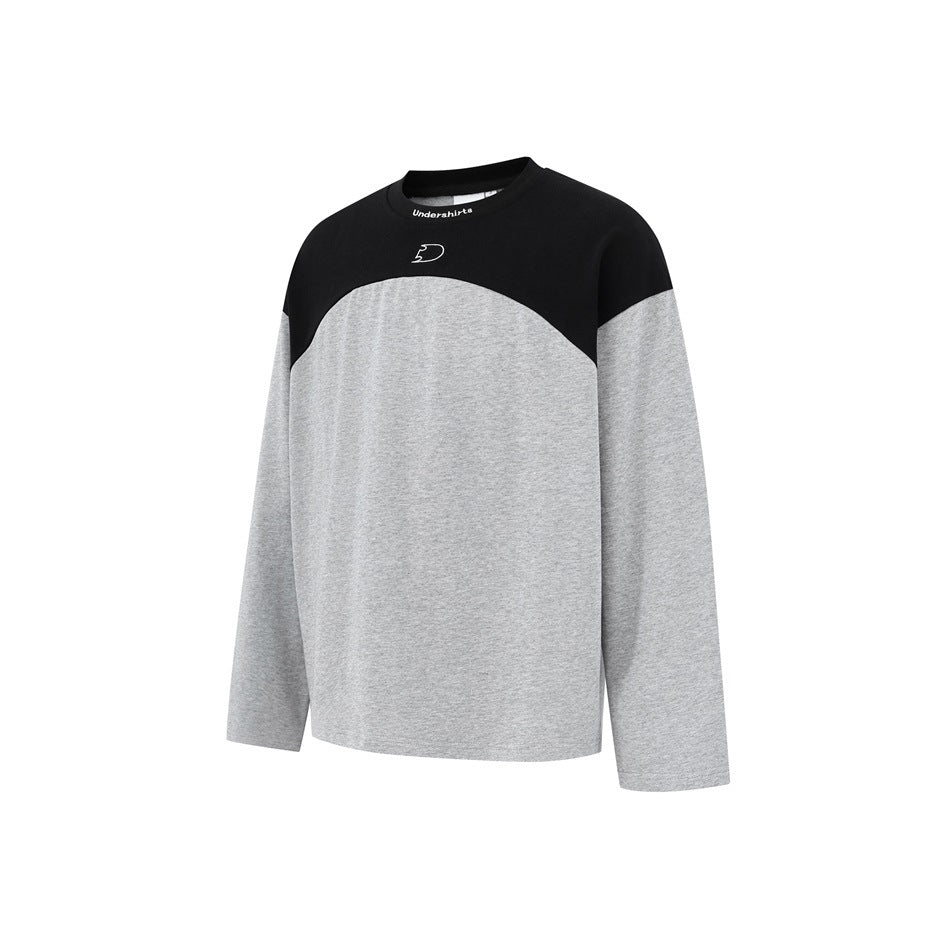 Front view of a long-sleeve crew-neck shirt with a black yoke and heather-gray body and sleeves, plus a small white chest