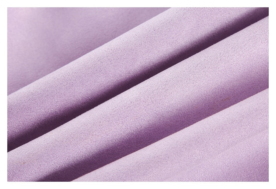 Close-up of lavender garment fabric arranged in soft folds, showing its fine surface texture.