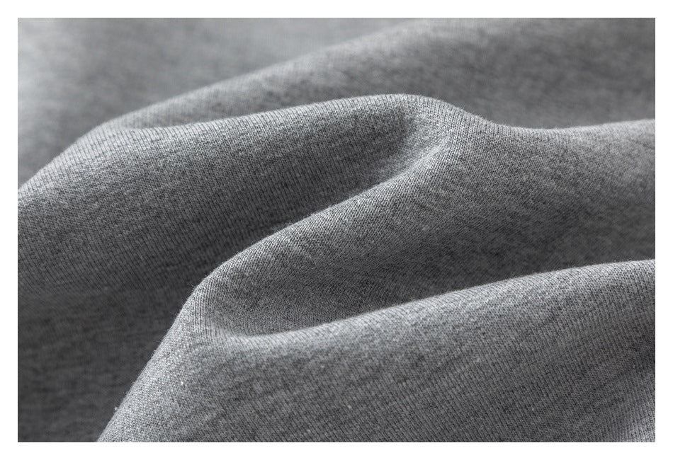 Macro view of the heather-gray sweatshirt fabric folded into soft ridges.