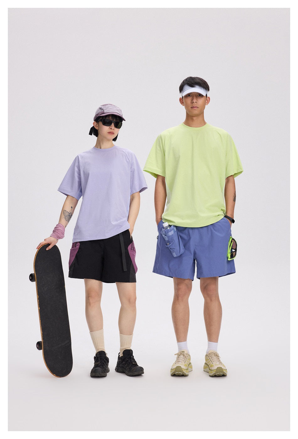 Two models wear loose short-sleeve T-shirts in lavender and pale lime, with contrasting shorts.
