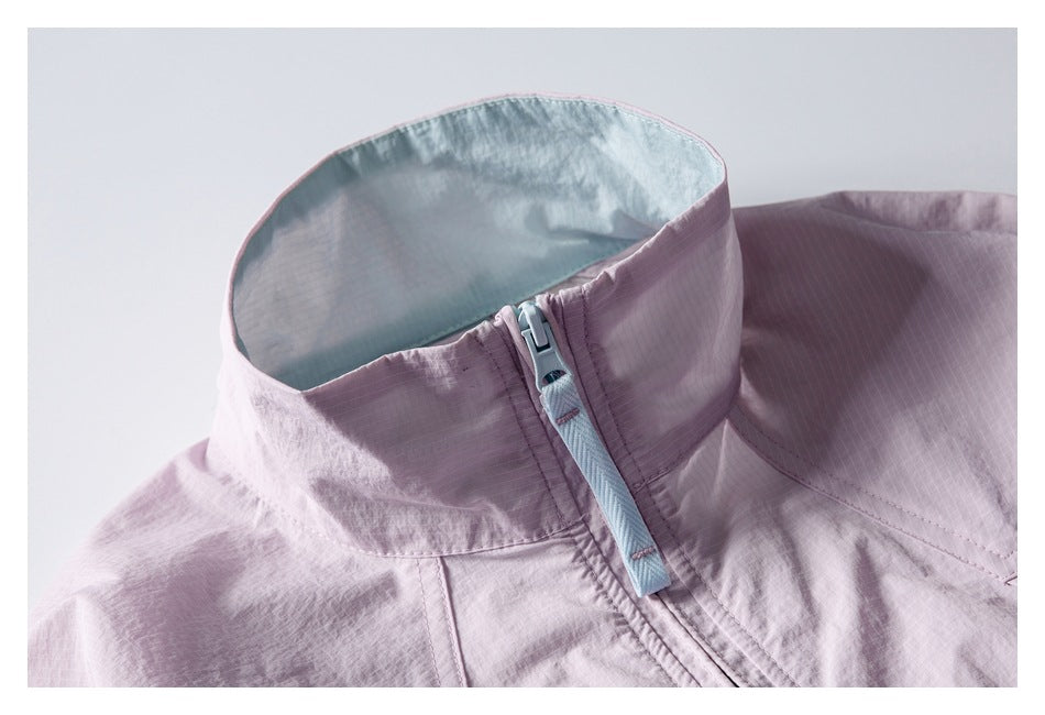 Close-up of a pale lavender jacket’s stand collar and zipper, with light blue lining and zipper tape.