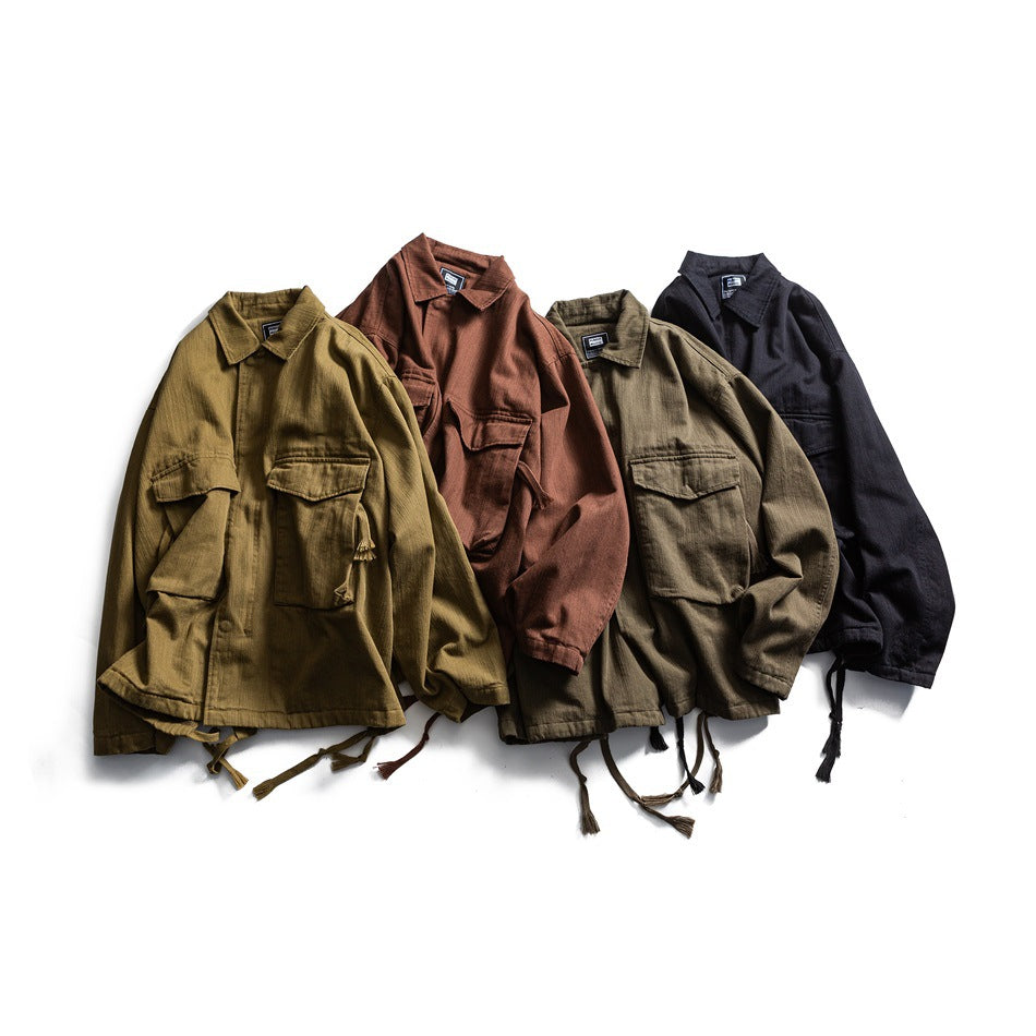 Four collared utility jackets with chest pockets and hem ties, shown in olive, rust, khaki, and black.