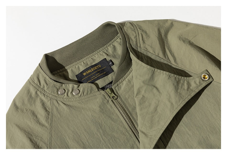 Close-up of an olive jacket's ribbed collar, zipper, snap-fastened storm flap, and sewn-in neck label.