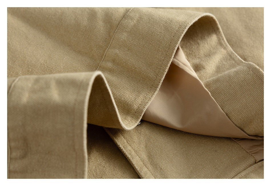 Close-up of the tan jacket opened to show its smooth beige lining and inner construction.