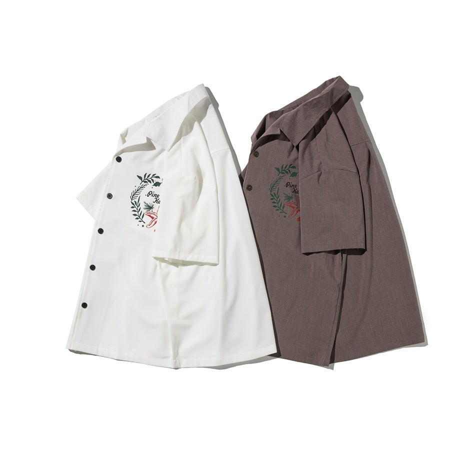 White and taupe short-sleeve button-up shirts with matching green and red sea-themed chest graphics.