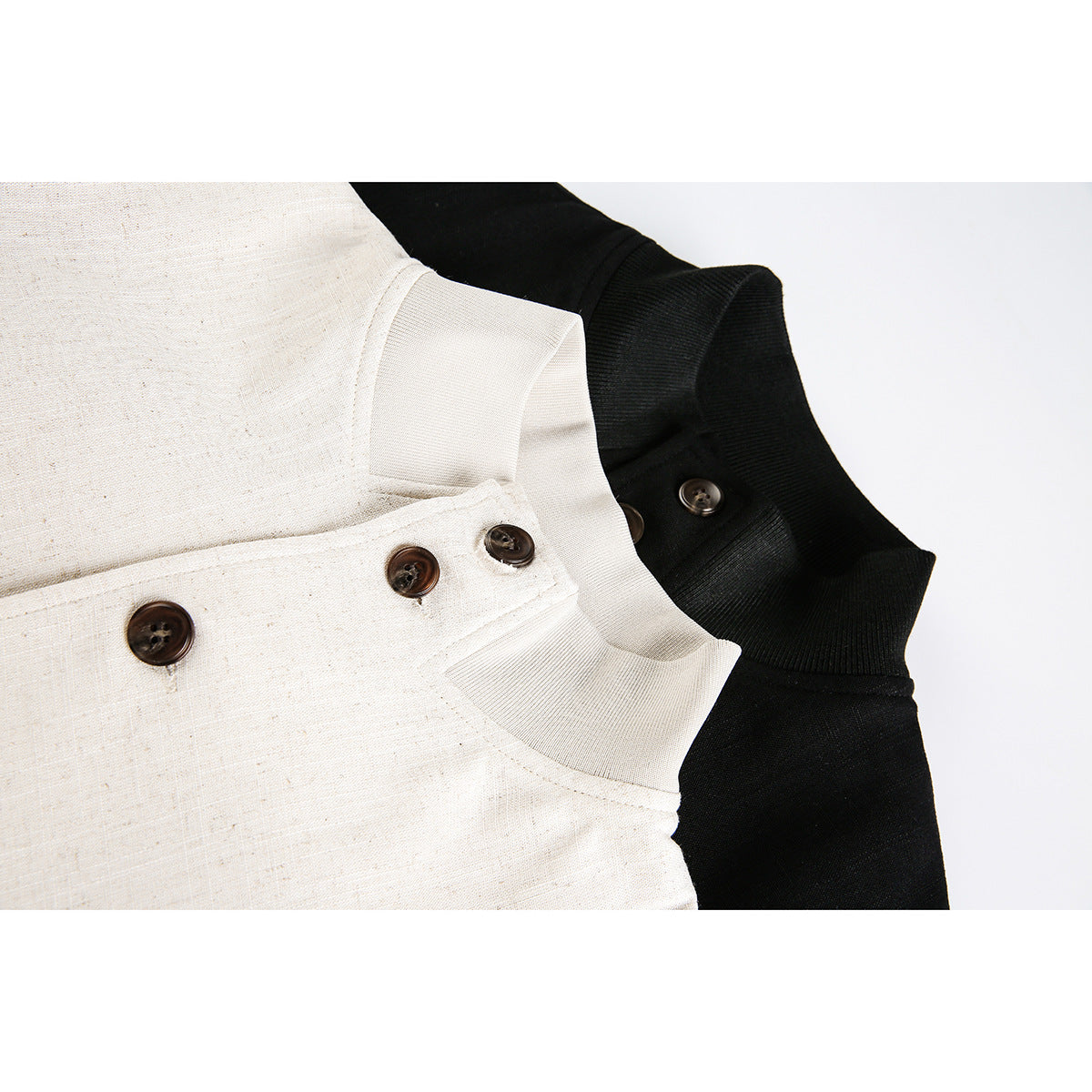 Close-up of cream and black stand collars with dark buttons and ribbed trim.