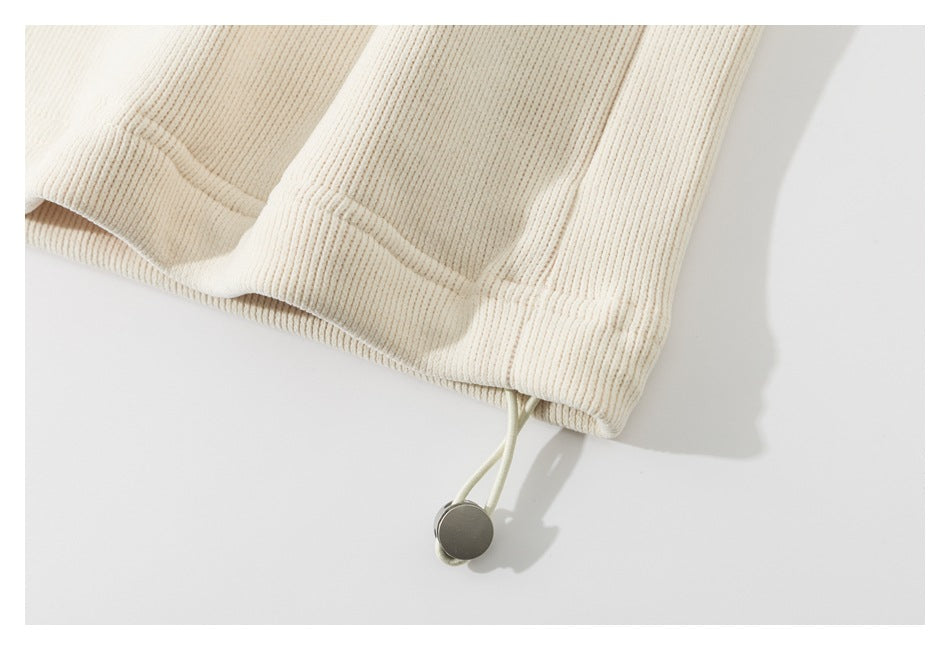 Close-up of the ribbed hem with an adjustable drawcord and round metal toggle.
