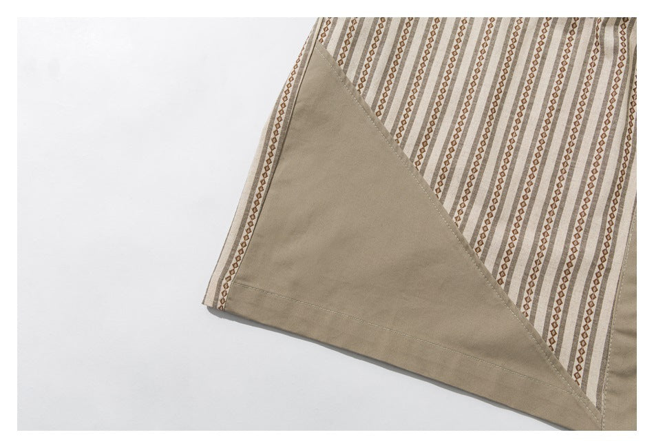 Close-up of a garment edge with a solid taupe triangular panel beside beige and brown vertical stripes.