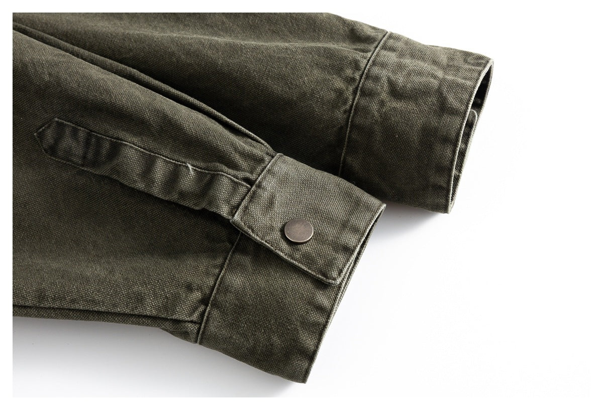 Close-up of the olive-gray shirt sleeve cuff with a metal snap and fabric tab.