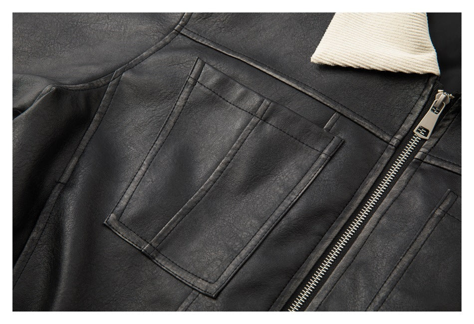 Close-up of the black jacket's chest pocket, contrast collar edge, and metal front zipper.