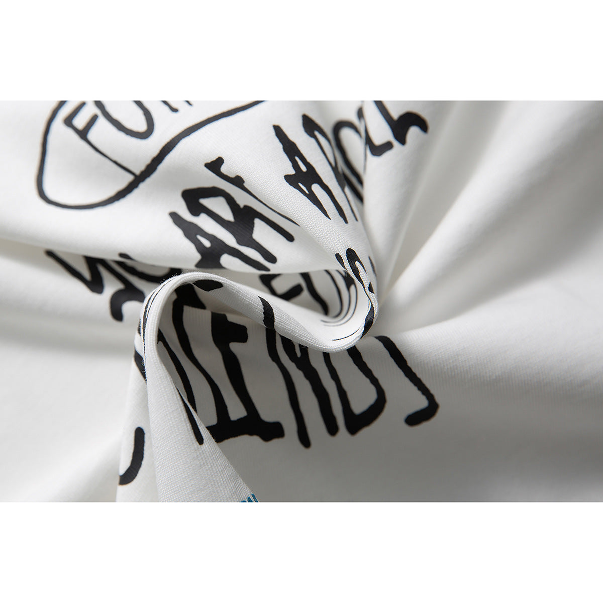Close-up of black graphic lettering printed on folded white T-shirt fabric.