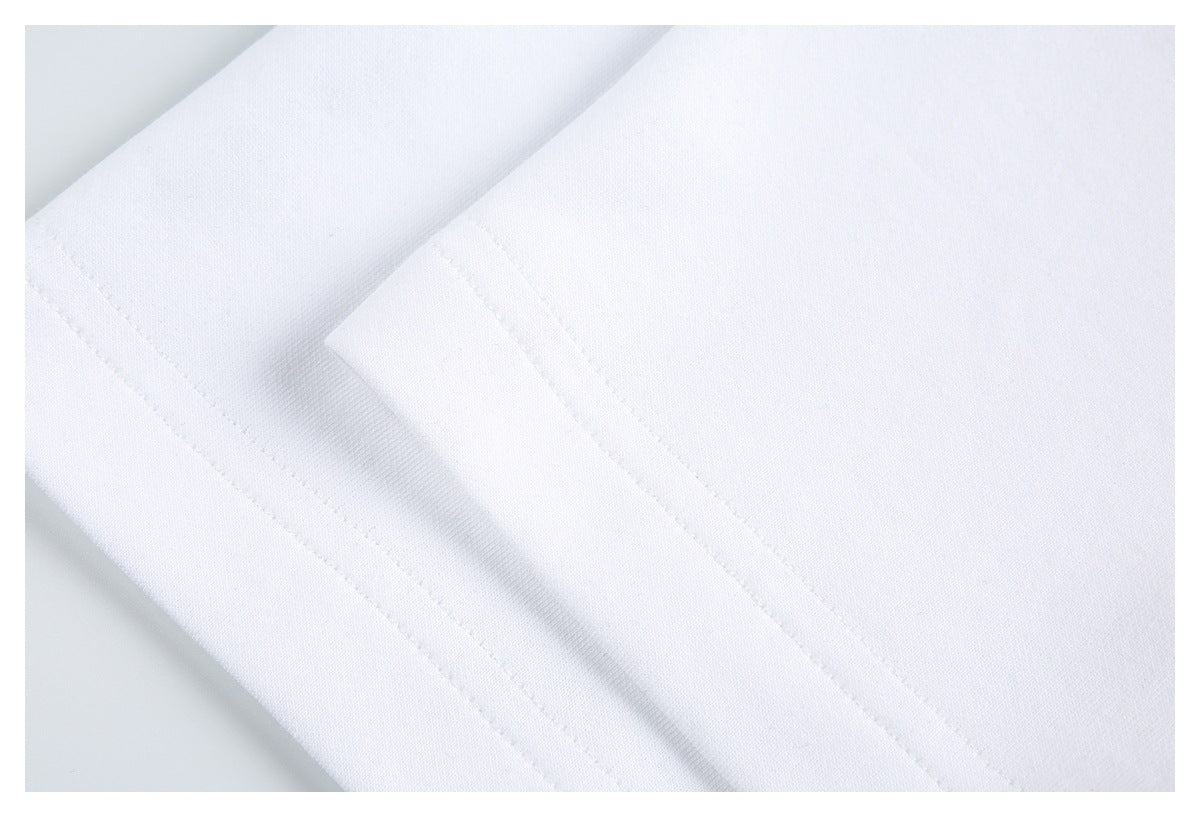Close-up of white garment fabric with a neatly stitched folded edge.