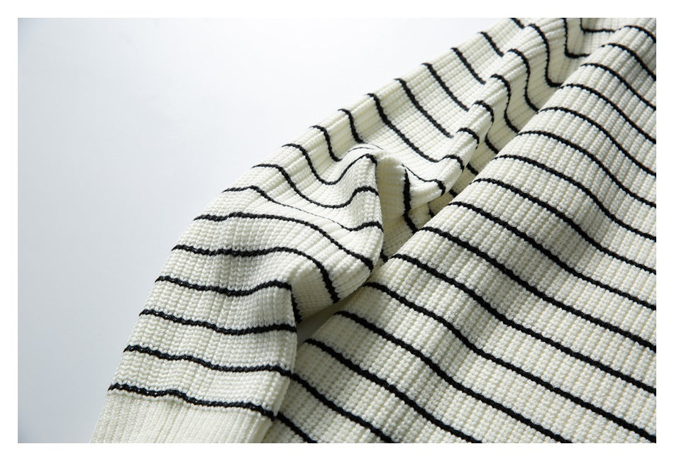 Close-up of the ivory sweater's black horizontal stripes and textured knit fabric.
