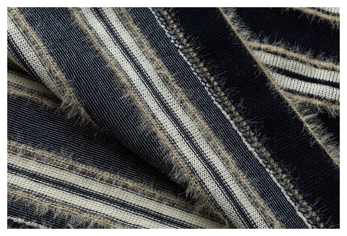 Close-up of the sweater’s reverse knit and overlocked seam among navy and cream stripes.